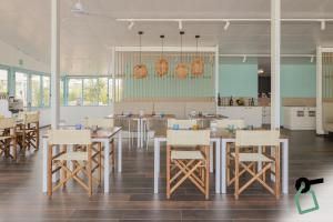 ein Esszimmer mit Tischen und Stühlen und eine Küche in der Unterkunft HOTIDAY Room Collection - Milano Marittima in Milano Marittima