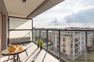an apartment balcony with a table and a view at SuperApart Przy Forcie 12 in Warsaw