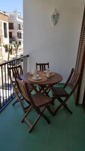 een houten tafel en stoelen op een balkon bij Apartamento Hector en Sitges in Sitges
