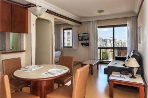 a living room with a table and a couch at Central Park Flat Jardins in São Paulo