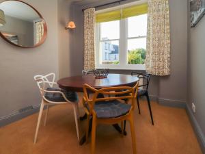 a dining room with a table and chairs and a window at Poets Retreat in Cockermouth
