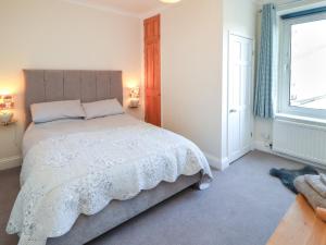 a bedroom with a large bed and a window at Poets Retreat in Cockermouth