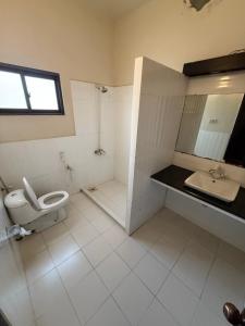 a white bathroom with a toilet and a sink at Shelton Accommodator in Peshawar +15 photos