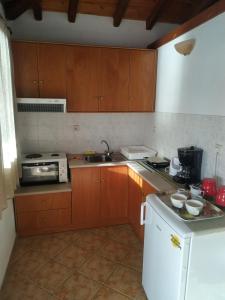 a kitchen with wooden cabinets and a sink and a stove at Ourania Sea Breath in Punta