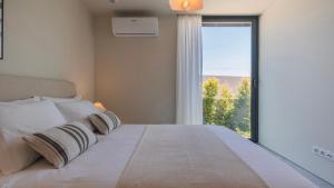 Un dormitorio con una cama grande con una ventana grande. en Stunning Beach House with Pool by LovelyStay, en Santo Isidoro 71 fotos más