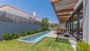 Un patio trasero con piscina, mesa y sillas. en Stunning Beach House with Pool by LovelyStay, en Santo Isidoro