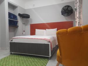 a bedroom with a bed and a chair at Executive Guest House Randfontein in Randfontein