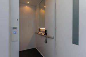 a walk in shower with a door with a mirror at Vakantiewoning aan het water 'Oester Oase' - met 2 balkons - Vista Maris - Nr 36 in Sint Annaland