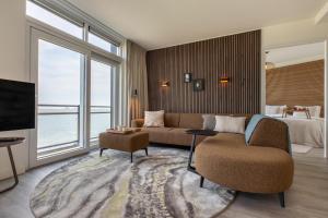 a living room with a couch and a tv and a bed at Vakantiewoning aan het water 'Oester Oase' - met 2 balkons - Vista Maris - Nr 36 in Sint Annaland +47 photos