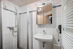 a white bathroom with a sink and a shower at Ferienwohnungen Talblick in Kirnbach +47 photos