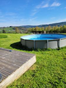 a swimming pool in the middle of a grass field at Cottage Fauna & Flora in Malmedy