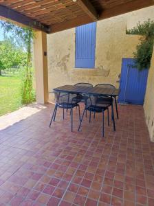 a table and chairs sitting on a patio at Les petits volets bleus in Bouchet