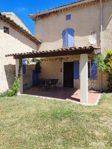 a patio outside of a house with a table at Les petits volets bleus in Bouchet +17 photos