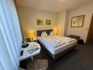 a hotel room with a bed and a side table at Hotel Löwen in Randersacker