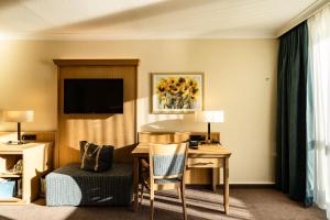 a hotel room with a desk and a room at Eibsee Hotel in Grainau
