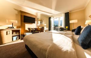 a hotel room with a bed and a living room at Eibsee Hotel in Grainau