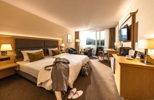 a hotel room with a bed with a backpack on it at Eibsee Hotel in Grainau