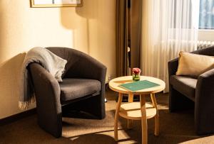 a living room with two chairs and a table at Eibsee Hotel in Grainau