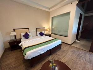 Postel nebo postele na pokoji v ubytování The Grand Paramont Near Delhi Airport Free Airport Drop