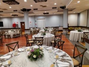 a banquet hall with white tables and chairs with flowers at Hotel Escuela Santa Brígida in Santa Brígida