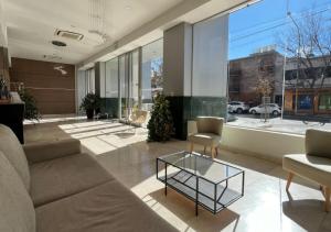 a living room with a couch and a glass table at Apart Hotel Quijote by DOT Suites in Ciudad Lujan de Cuyo