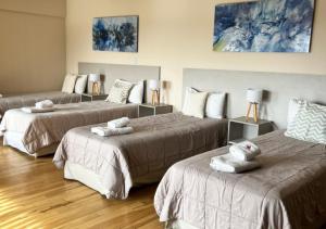 three beds in a room with wooden floors at Apart Hotel Quijote by DOT Suites in Ciudad Lujan de Cuyo