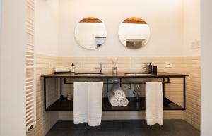a bathroom with a sink and two mirrors at Bassano Club House in Bassano del Grappa +43 photos