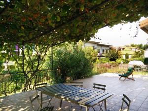 una mesa de picnic y sillas en un patio en Le Magnolie B&B, en Bussero