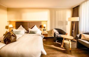 a hotel room with a large bed and a couch at Eibsee Hotel in Grainau