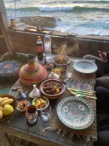 a table with plates of food on top of it at Tamri Beach Cabane in Tamri