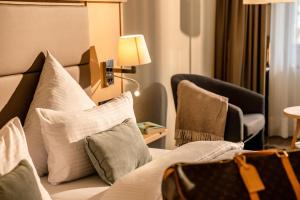 a hotel room with a bed with pillows and chairs at Eibsee Hotel in Grainau