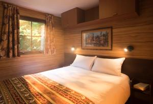 1 dormitorio con 1 cama blanca y ventana en Disney Davy Crockett Ranch, en Villeneuve-le-Comte 36 fotos más