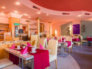 a restaurant with tables and chairs with pink napkins on them at Park Hotel in Konz