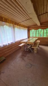 an empty room with a wooden table and a bench at Таежный домик Васильево in Poperechnoye