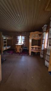 an empty room with bunk beds and a table at Таежный домик Васильево in Poperechnoye