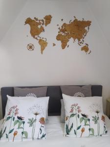 Tadenにあるduplex de charme à Dinanの枕が置かれたベッドの上の壁には世界地図が描かれている