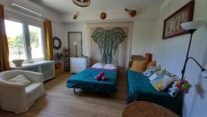 a living room with two beds and a chair at La cacarinette in Rayol-Canadel-sur-Mer