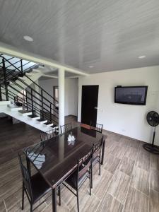 una sala da pranzo con tavolo, sedie e TV a schermo piatto di Casa de Char Girardot, Nariño Cundinamarca a Nariño Altre 17 foto