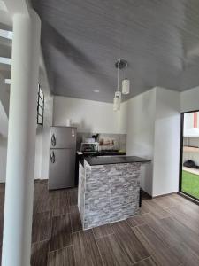 una cucina con bancone in pietra e frigorifero di Casa de Char Girardot, Nariño Cundinamarca a Nariño