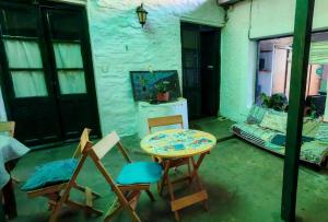 a room with a table and chairs and a couch at Hostel Colibri Colonia in Colonia del Sacramento