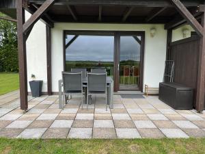 a patio with a table and chairs and a glass door at Ferienwohnung Ostseeland 1 in Börgerende-Rethwisch