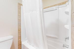 a bathroom with a shower and a white tub at Night at the Inn in Bend +16 photos