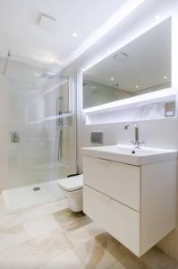 een witte badkamer met een wastafel en een toilet bij Luxury 2 bed/bath apartment next to Hyde Park in Londen