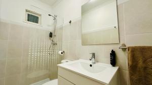 a white bathroom with a sink and a shower at Vital by Check-in Portugal in Albufeira