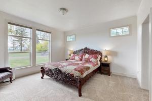 a bedroom with a bed and two windows at Legendary Farms in Columbia Falls
