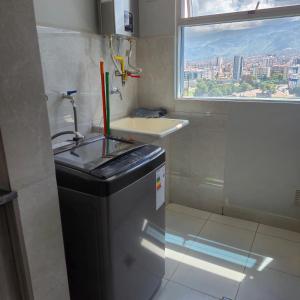 a small bathroom with a sink and a window at Premium Apartamentos Torre Azul in Cochabamba
