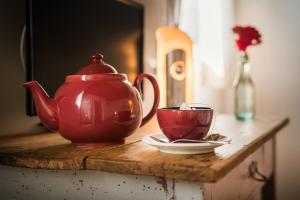 eine rote Teekanne und eine Tasse auf dem Tisch in der Unterkunft Villa Ca Bruna Holiday House in San Giorgio di Livenza