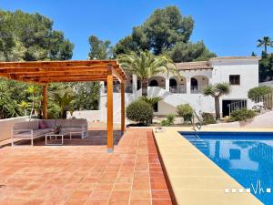 a patio with a pergola next to a swimming pool at VH CostaBlanca - MIRASOL in Fanadix