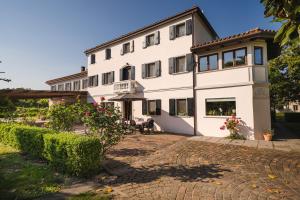 ein großes weißes Gebäude mit einem gemauerten Innenhof in der Unterkunft Villa Ca Bruna Holiday House in San Giorgio di Livenza