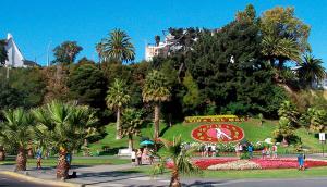 a park with a clock on a hill with palm trees at Hotel Cerro Castillo in Viña del Mar